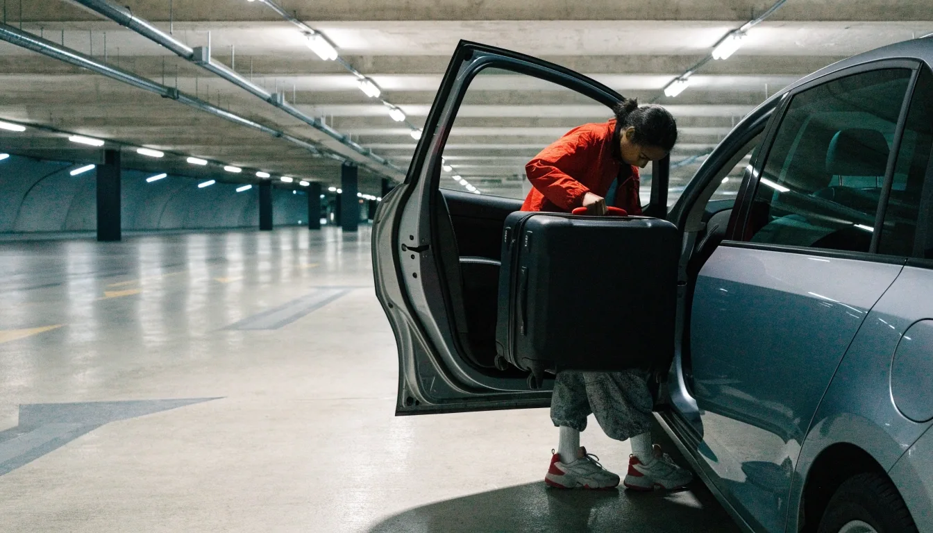 A bay lane inside an undercover multi-level car park with fluorescent tubes overhead and one vehicle parked mid-distance