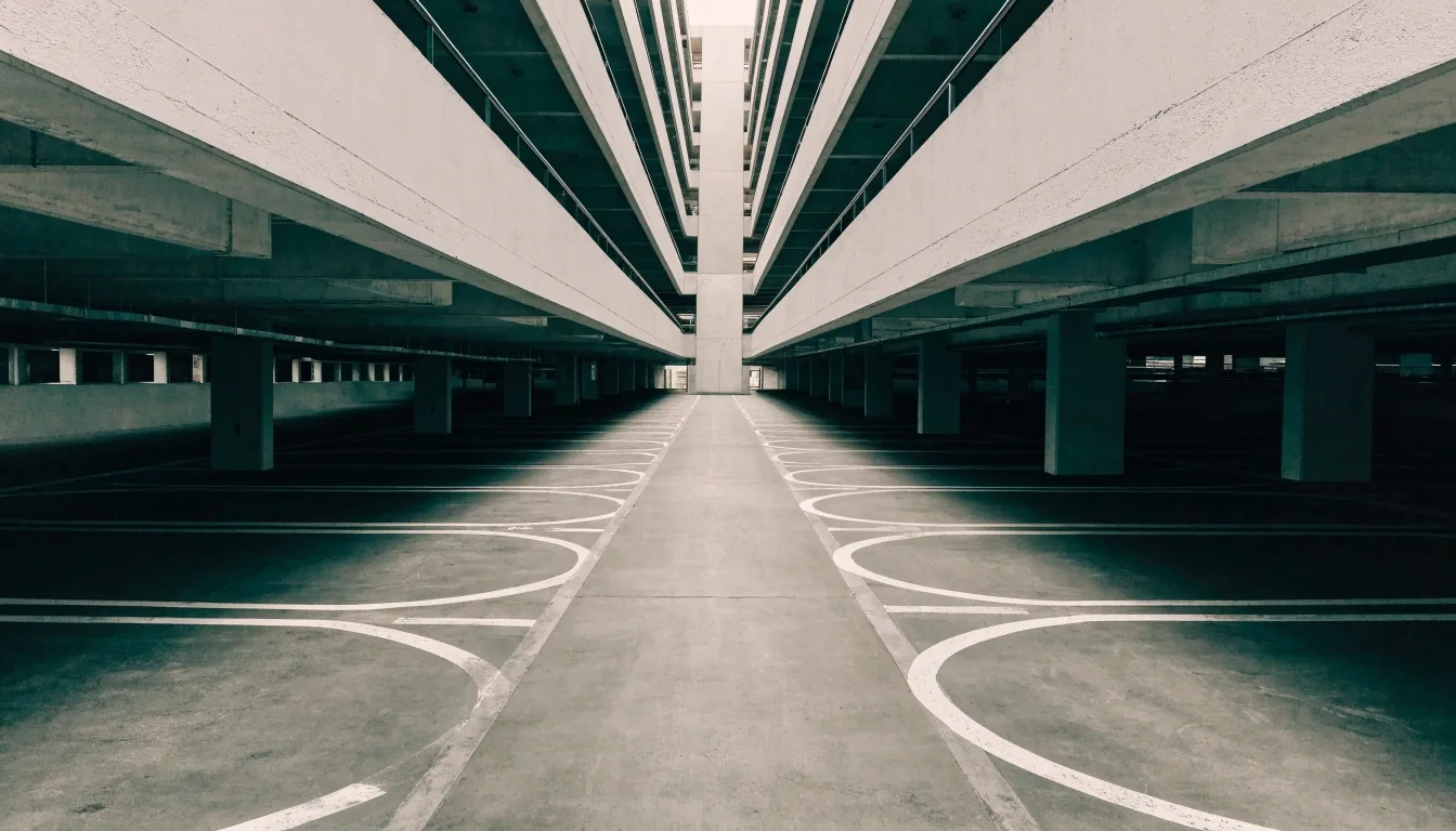 Undercover multi-level car park deck at Brisbane Airport with painted bay lines and flat overhead light