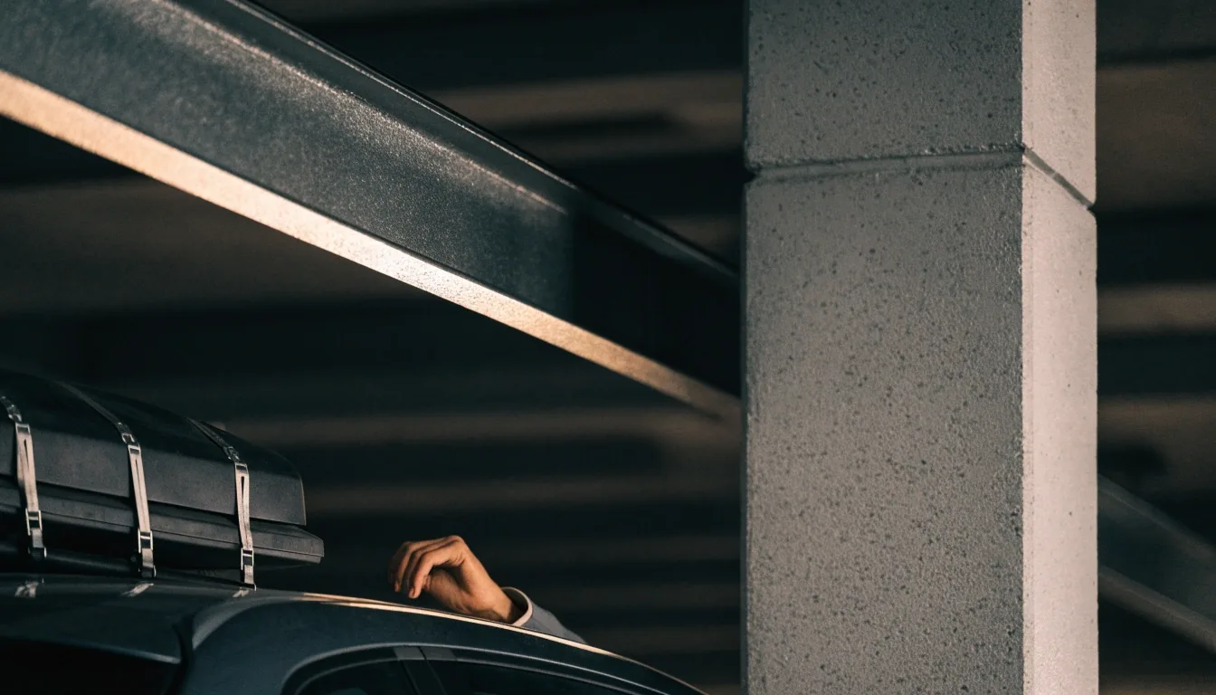 Ceiling beam meeting a painted concrete column inside an undercover car park