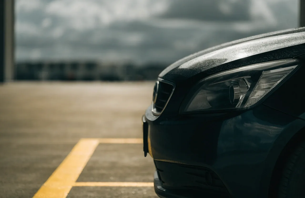 Front of a car parked into a marked bay at a Brisbane airport car park, cropped at the bonnet