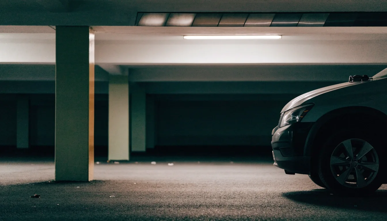 Low concrete ceiling and beam inside an undercover Brisbane airport parking level under flat overhead light